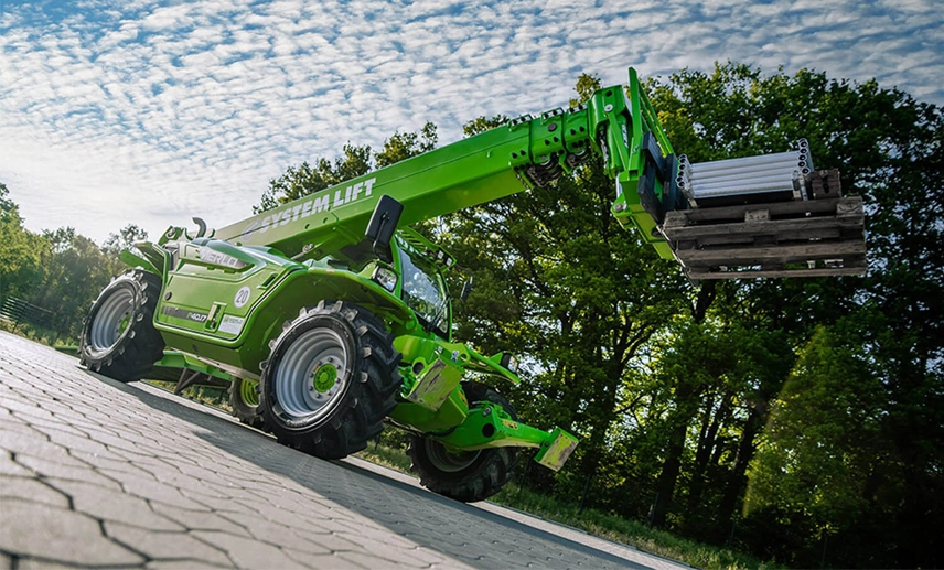Arbeitsbühne gebraucht mit Teleskoparm vor einem Waldstück